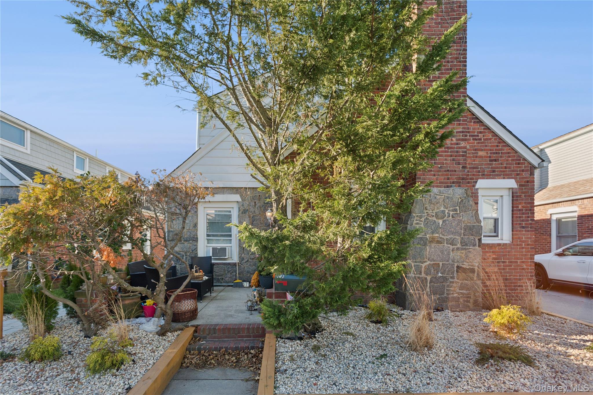 107 Pacific Boulevard Long Beach, NY 11561 - Photo 20 of 23 View of front of house with a patio, stone siding, and brick siding