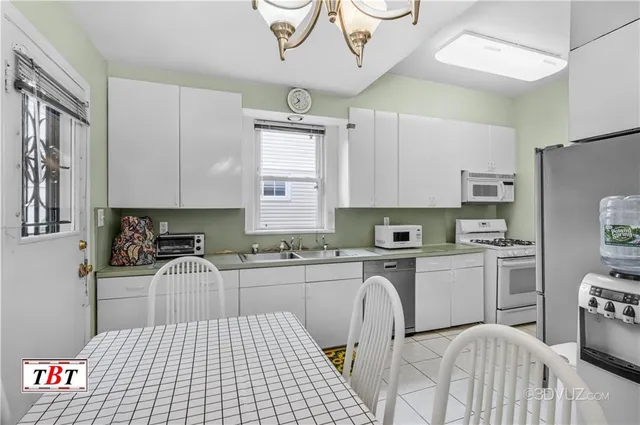 a kitchen with stainless steel appliances a sink a stove a refrigerator cabinets and a window