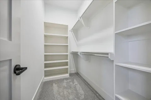 a view of walk in closet with empty racks