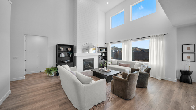 324 North Rhyolite Drive, Unit 87 Hurricane, UT 84737 - Photo 8 of 33 Living area featuring wood finished floors, a high ceiling, and a fireplace