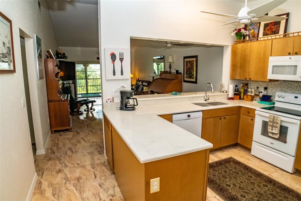 175 Kings Highway, Unit 933 Punta Gorda, FL 33983 - Photo 8 of 32 a kitchen with a stove a sink a refrigerator and a dining table