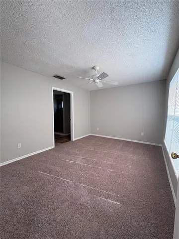 a view of an empty room with a chandelier fan