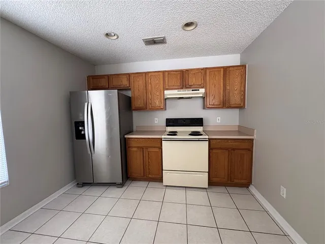 a kitchen with a refrigerator sink and cabinets