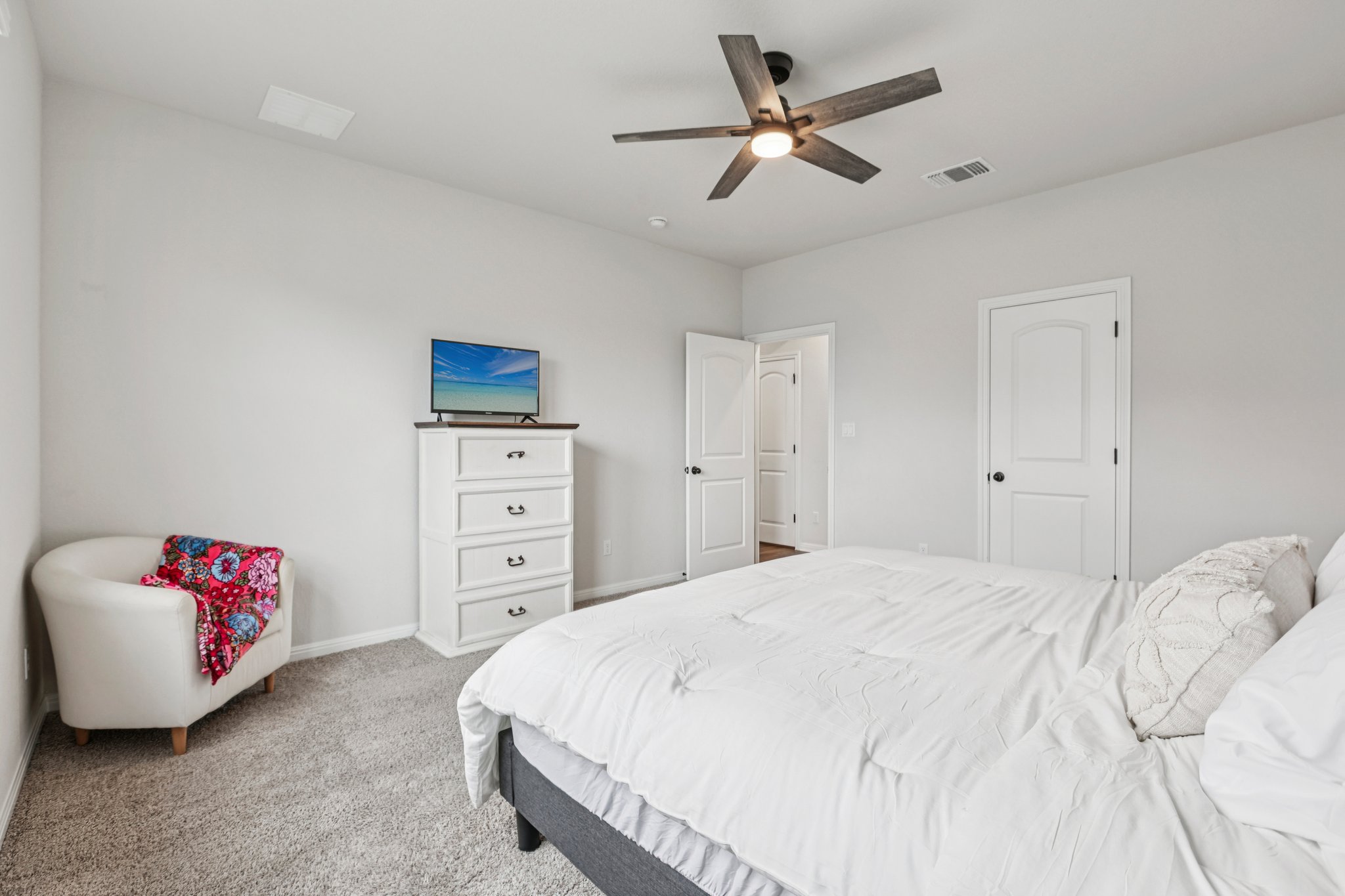 204 Swinging H Lane Georgetown, TX 78633 - Photo 13 of 39 a spacious bedroom with a bed and a chandelier