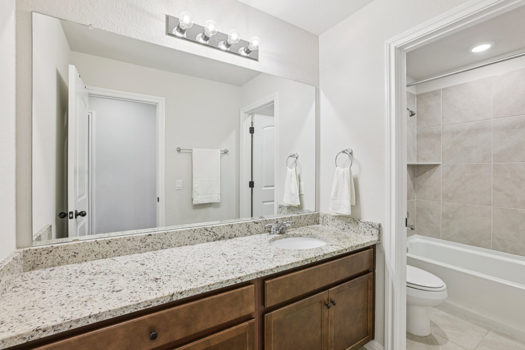 204 Swinging H Lane Georgetown, TX 78633 - Photo 28 of 39 a bathroom with a granite countertop sink a toilet and shower
