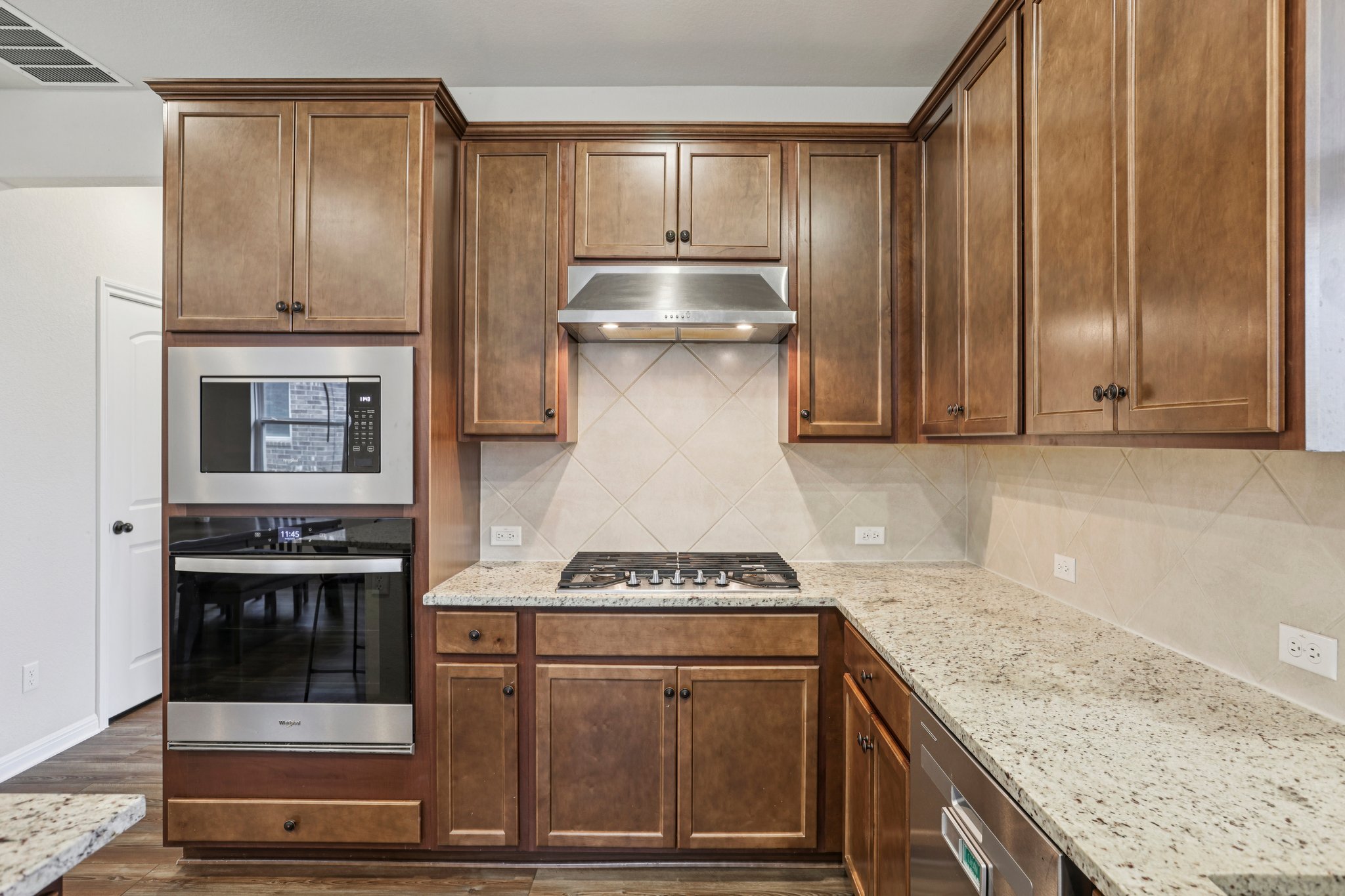204 Swinging H Lane Georgetown, TX 78633 - Photo 9 of 39 a kitchen with granite countertop cabinets stainless steel appliances and wooden floor
