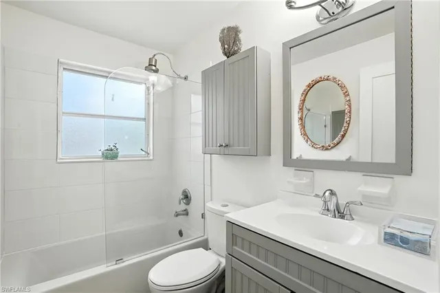 a bathroom with a granite countertop sink a toilet and a mirror