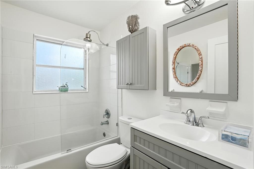 578 14th Street North Naples, FL 34102 - Photo 19 of 28 a bathroom with a granite countertop sink a toilet and a mirror