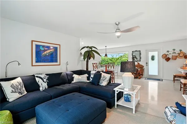 a living room with furniture and a ceiling fan