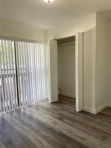 an empty room with wooden floor and a window