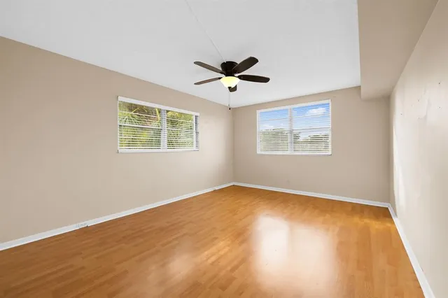 a view of an empty room with a window and a ceiling fan