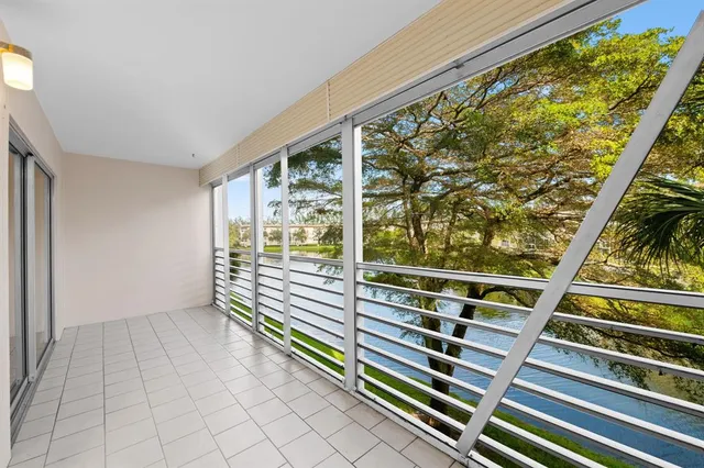 a view of an empty room with wooden floor and windows