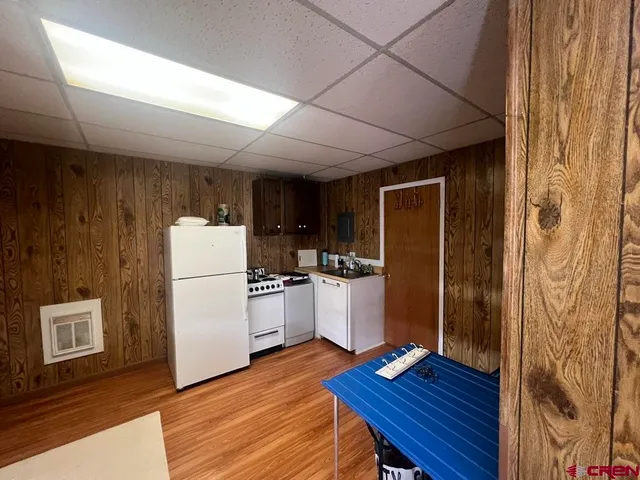 a kitchen with a refrigerator a stove and wooden floor