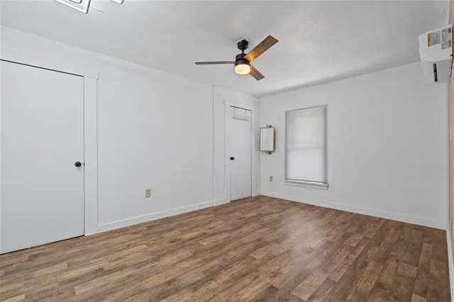 a view of room with wooden floor and ceiling fan