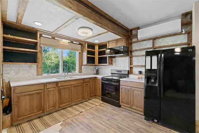a kitchen with stainless steel appliances granite countertop a sink and wooden cabinets