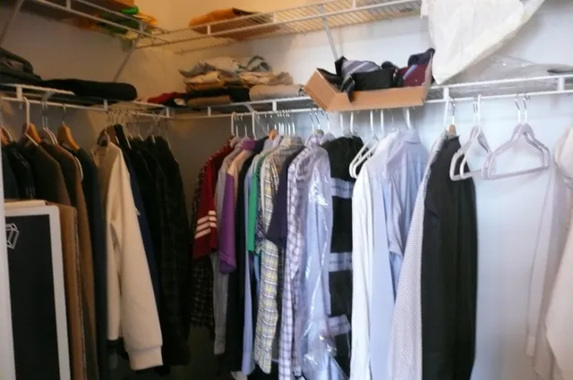 a view of walk in closet with clothes and shoes