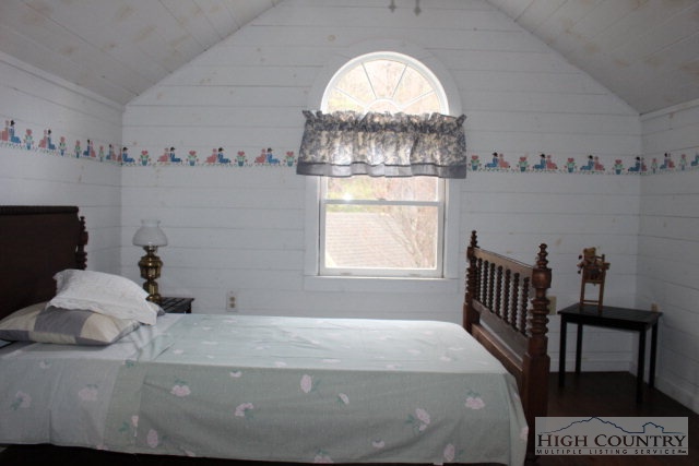 1824 Benge Ashe Road Purlear, NC 28665 - Photo 10 of 22 a bedroom with a bed and a chandelier