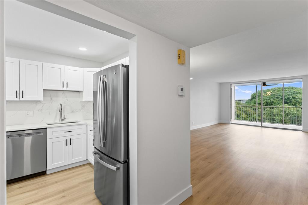 3000 South Course Drive, Unit 607 Pompano Beach, FL 33069 - Photo 11 of 33 a kitchen with stainless steel appliances a refrigerator sink and wooden floor