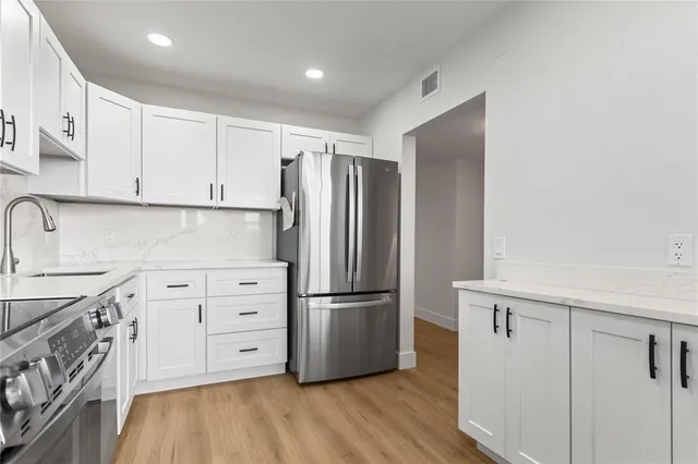 a kitchen with stainless steel appliances granite countertop a refrigerator a stove and a microwave