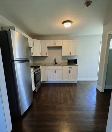 a kitchen with stainless steel appliances a refrigerator sink and wooden floor