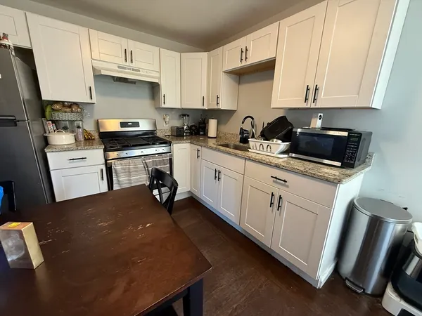 a kitchen with white cabinets and appliances