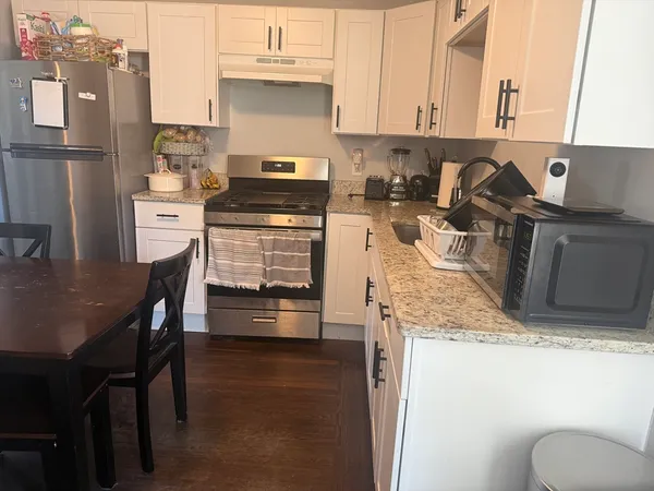 a kitchen with granite countertop a sink stove and refrigerator