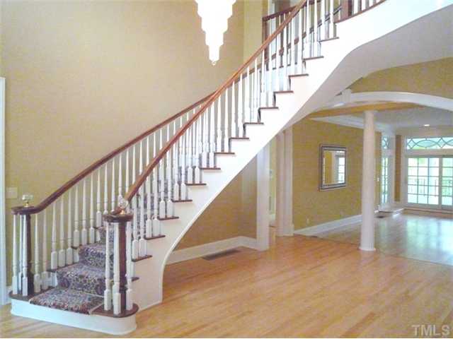 1817 Brassfield Road Raleigh, NC 27614 - Photo 10 of 25 a view of staircase with wooden floor and a chandelier