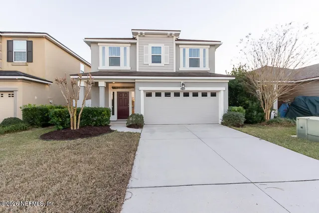 a front view of a house with a yard and garage