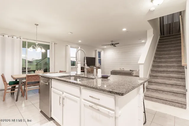 a living room with furniture and a view of kitchen