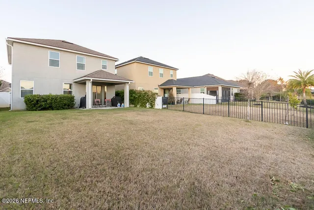 a view of a house with a big yard and large trees