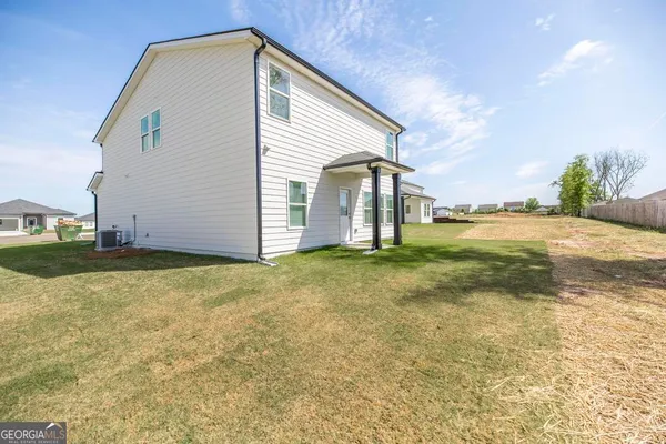 a view of a house with backyard and sitting area
