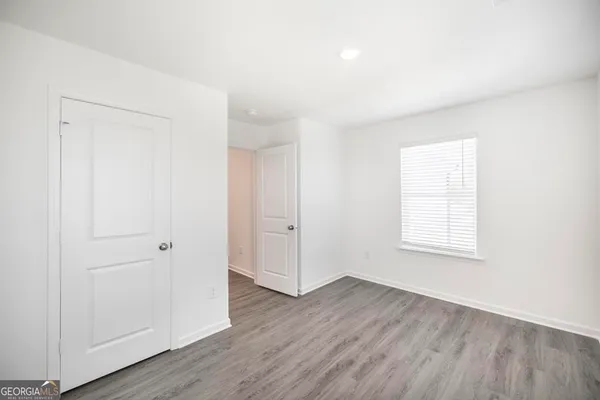 an empty room with wooden floor and window