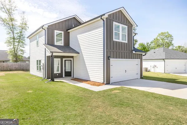 a view of a house with a yard and a garage