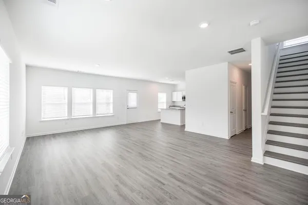 a view of empty room with wooden floor and window