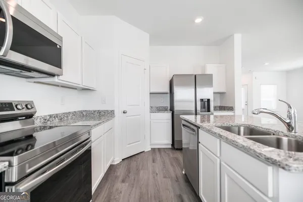 a kitchen with stainless steel appliances granite countertop a sink stove and refrigerator
