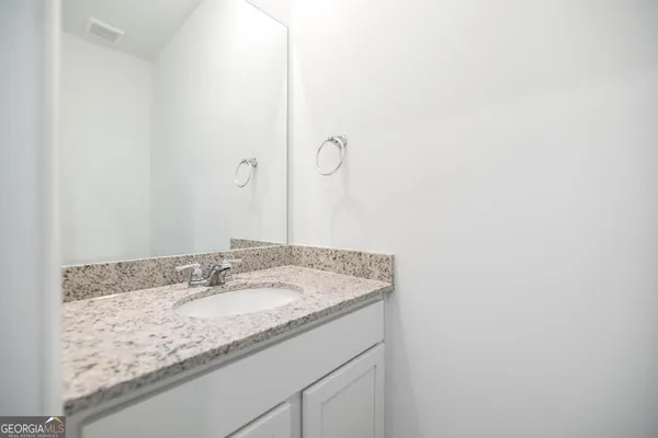 a bathroom with a granite countertop sink and vanity