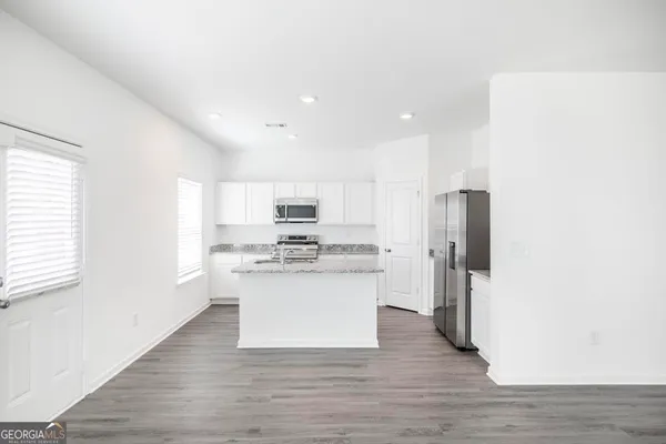 a kitchen with stainless steel appliances a refrigerator and a stove top oven