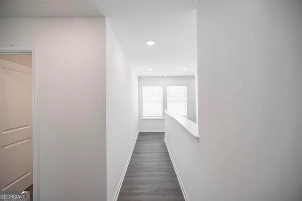 a view of a hallway with wooden floor and a window
