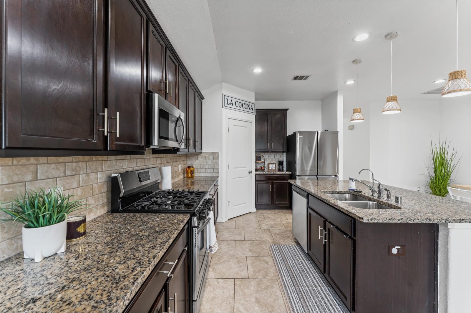 3007 Magellan Ridge Lane Baytown, TX 77521 - Photo 10 of 34 a kitchen with stainless steel appliances granite countertop a sink a stove and a wooden floors