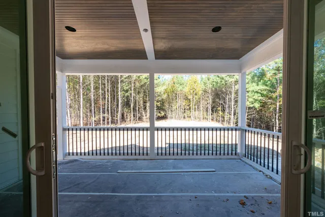 a view of a hallway with wooden floor and windows
