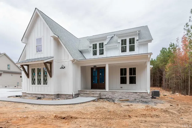 a view of a white house with a yard and large tree