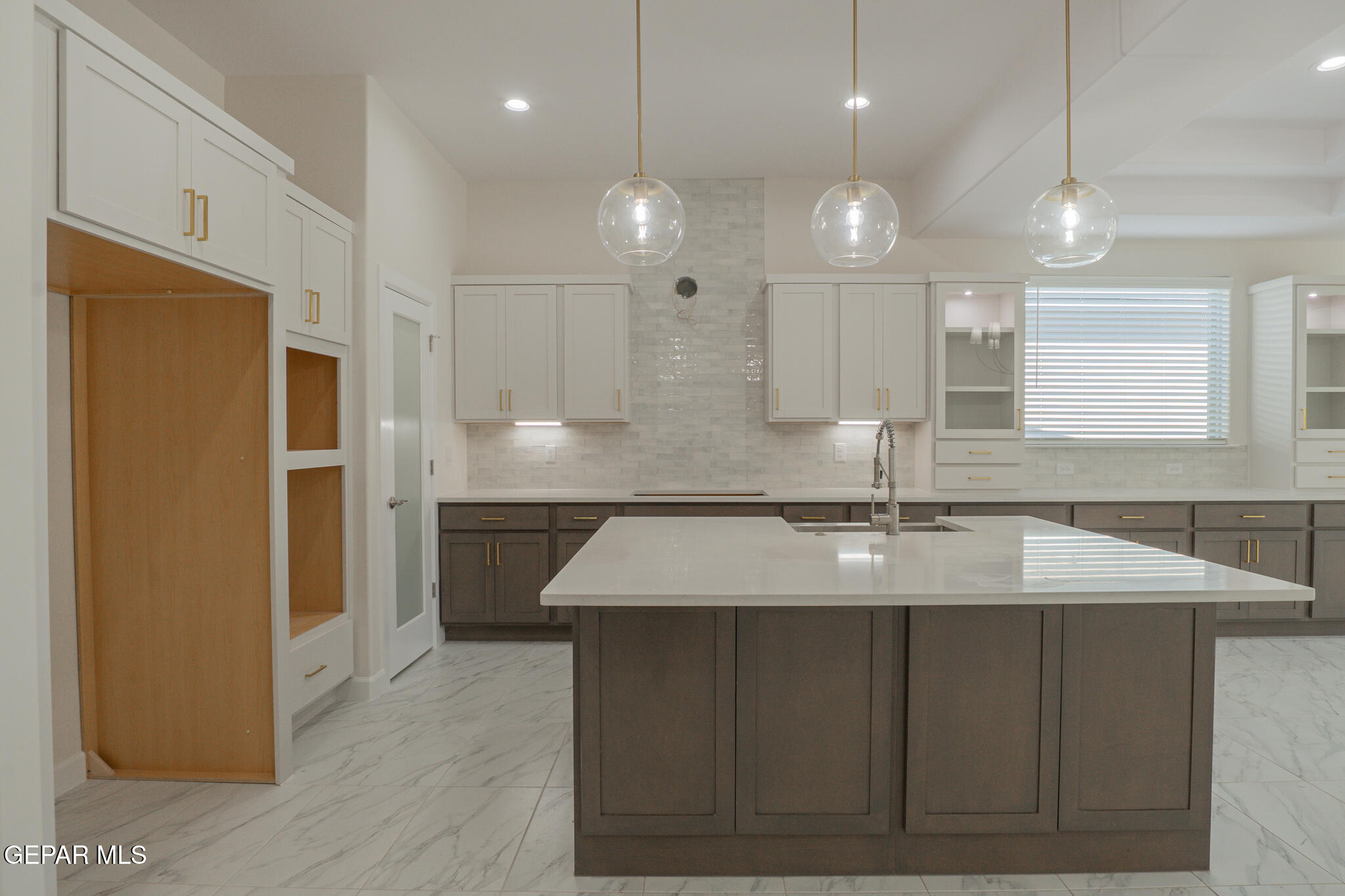 3769 Course Street El Paso, TX 79938 - Photo 8 of 34 a large kitchen with a center island wooden floor stainless steel appliances and a window