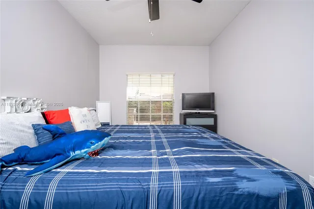 a spacious bedroom with a bed and a chandelier