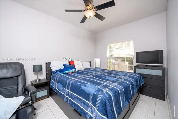 a spacious bedroom with a bed and a chandelier