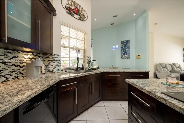 a living room with furniture a rug potted plant and a large window