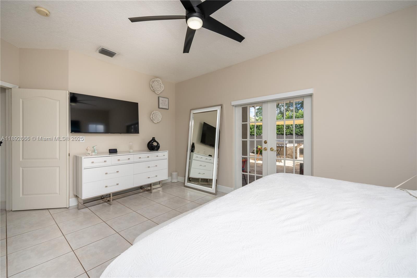 2275 Southwest 143rd Court Miami, FL 33175 - Photo 31 of 64 a large bedroom with a large bed and a flat screen tv