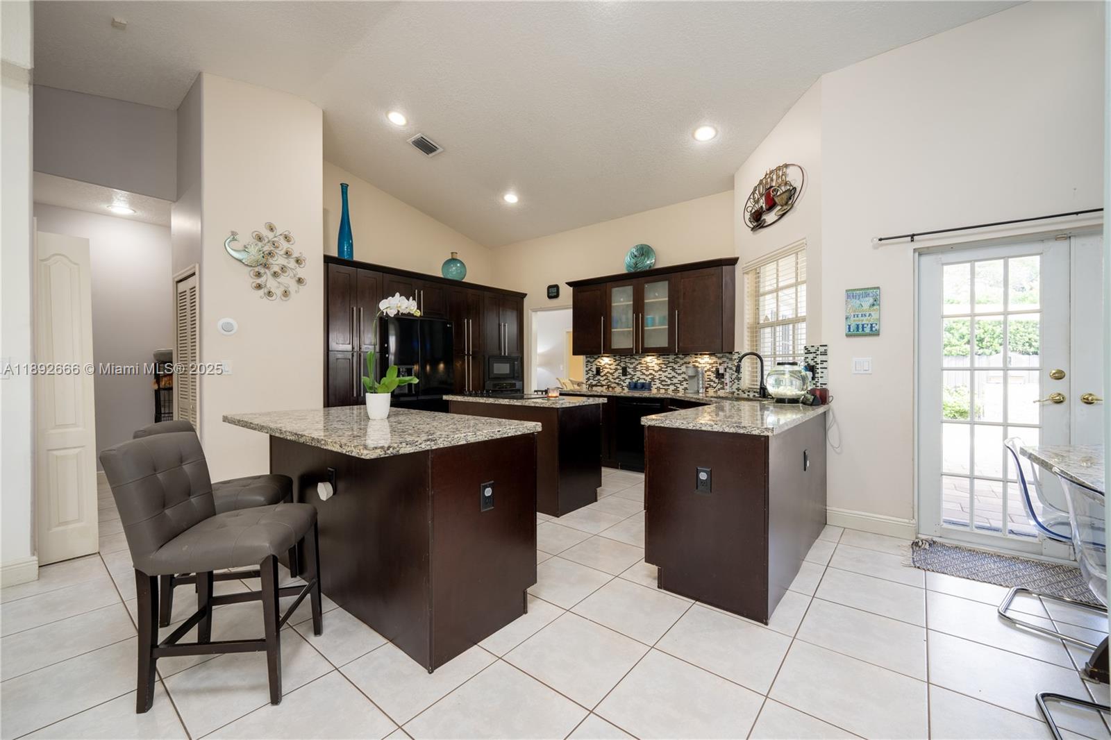 2275 Southwest 143rd Court Miami, FL 33175 - Photo 8 of 64 a kitchen with a refrigerator a sink a dining table and chairs
