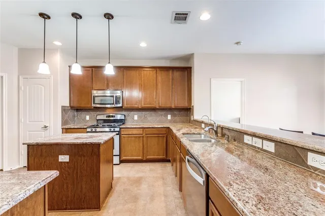 a kitchen with stainless steel appliances granite countertop a sink stove and refrigerator