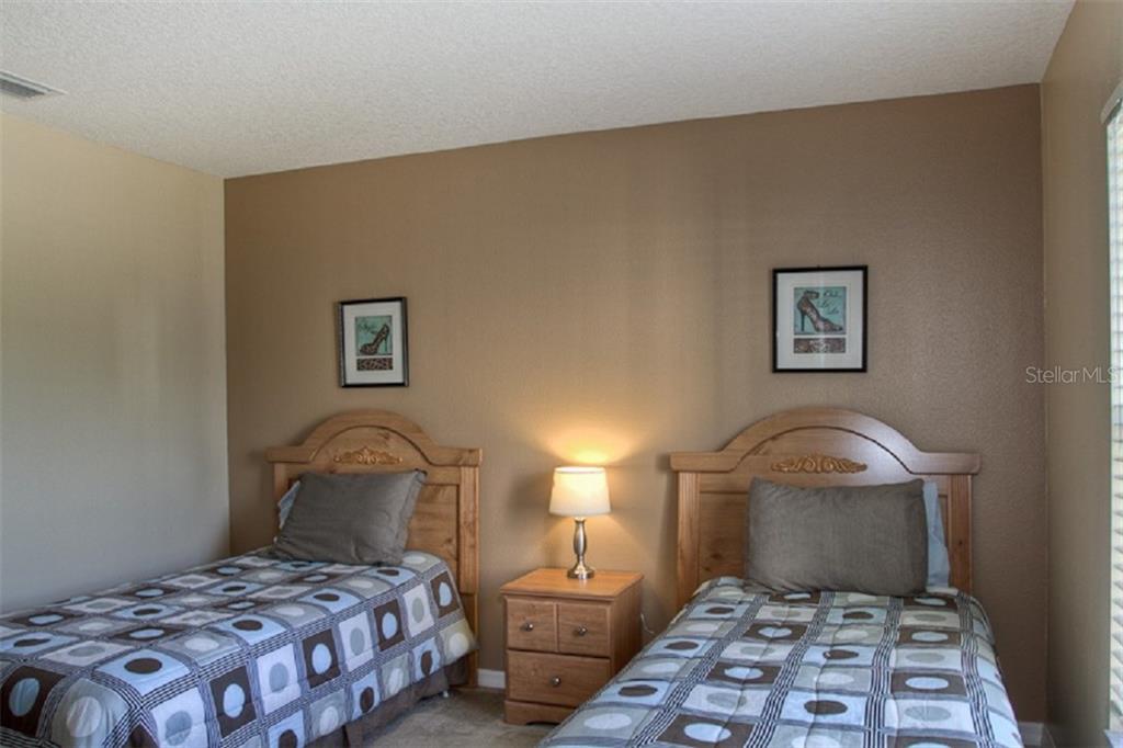 4418 Useppa Drive Bradenton, FL 34203 - Photo 12 of 22 a bedroom with a bed and a lamp