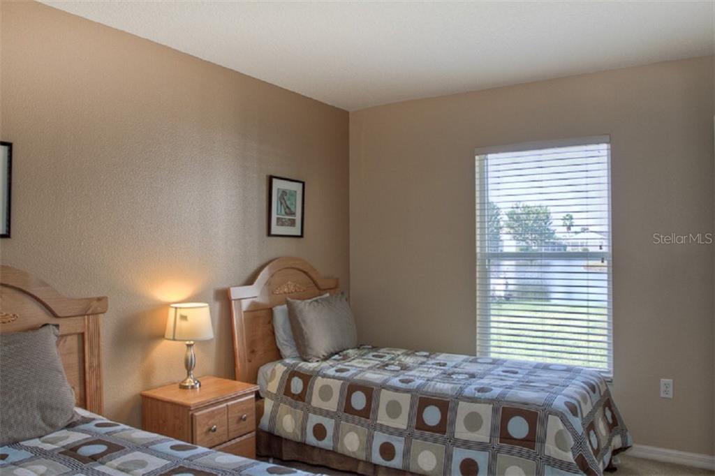 4418 Useppa Drive Bradenton, FL 34203 - Photo 13 of 22 a bedroom with a bed next to a window